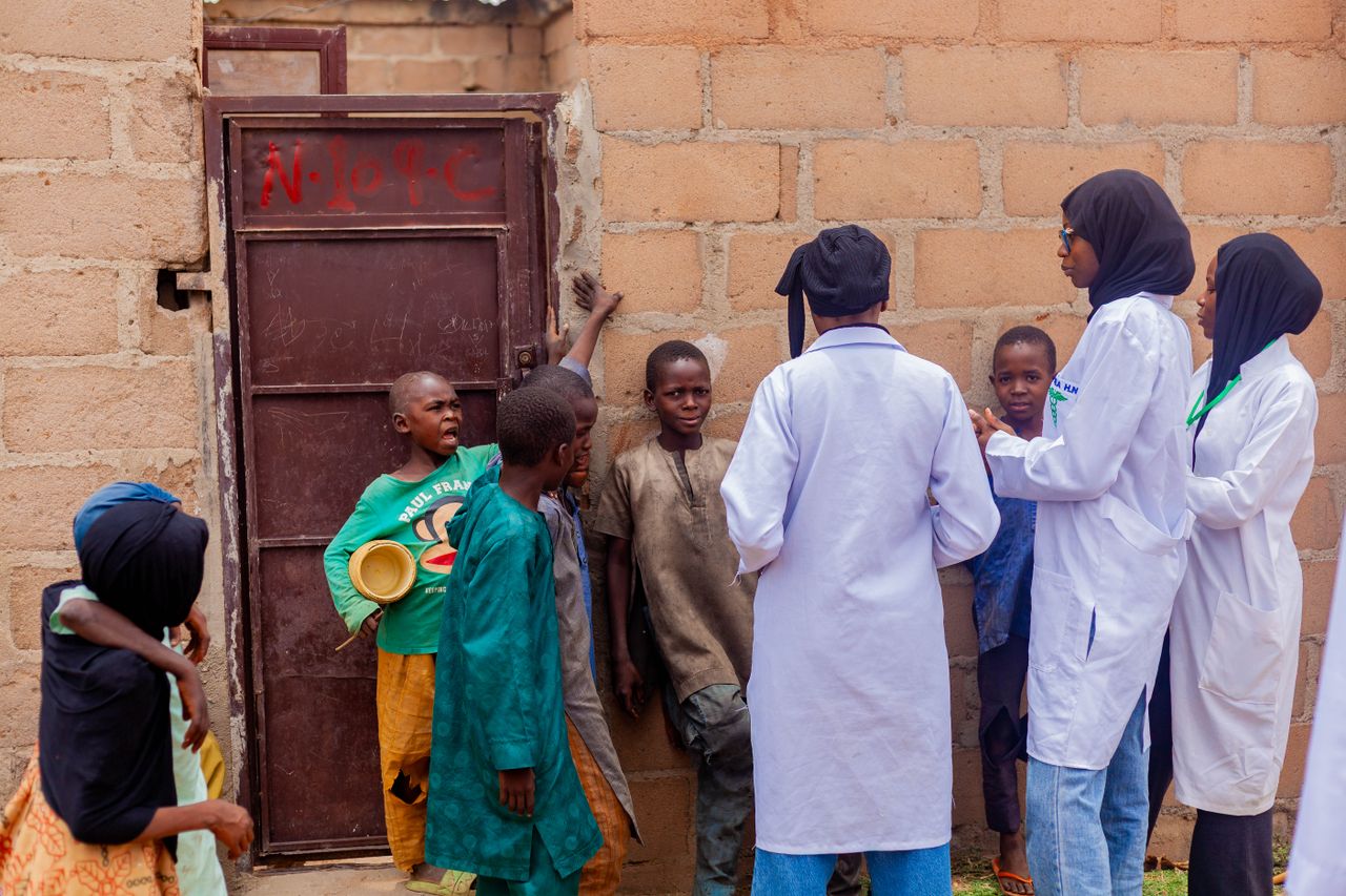 Healthcare workers engage with children in Gombe, Nigeria, promoting community health awareness.
